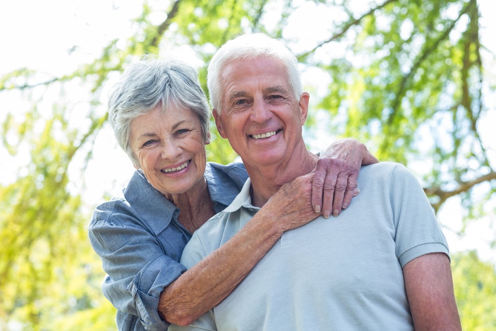 Happy old couple smiling in a park on a sunny day-1